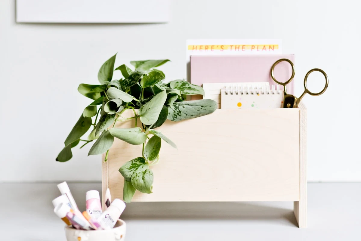 A sleek, handmade wooden desk organizer holding stationary on a desk, perfect as a functional and cute wood project for a teen's room.